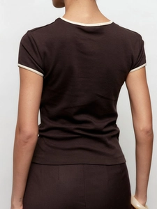 Détail du liseré contrasté au col et aux manches d'un t-shirt marron en maille