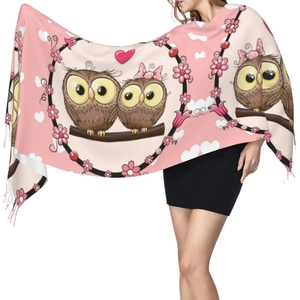 Close-up of pink cashmere-like scarf featuring cute owl patterns and tassel fringe details
