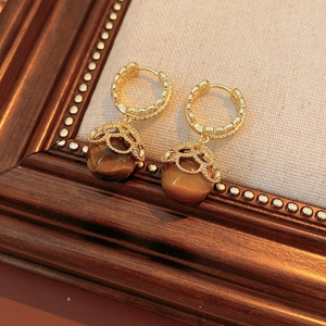 Detailed close-up of vintage gold plated earrings with brown tiger eye beads and floral metal caps