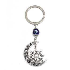 Dettaglio del ciondolo luna e sole vintage con perla occhio blu sul portachiavi