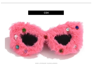 Close-up of pink faux fur cateye sunglasses with sparkling colorful rhinestone details