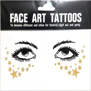 Detailed view of face art tattoos featuring metallic gold stars and black eye contour lines