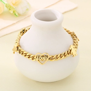 Detail of gold-plated bracelet with love heart charm and boy-girl pendants on vase
