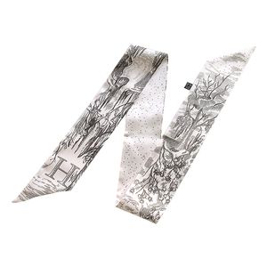 Detail of a black and white hand-drawn twilly silk scarf featuring the letter H and leaf patterns