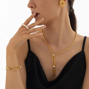 Parure de bijoux en or avec chaîne torsadée, pendentif à pompon et accents de diamants