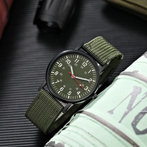Tactical military watch detail with green canvas strap and black metal case finish