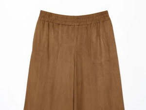Gros plan détaillé d'un pantalon en similicuir marron avec une taille élastiquée