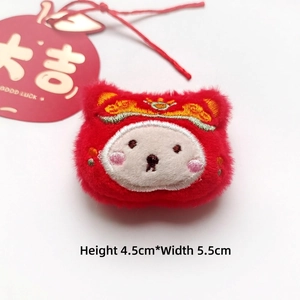 Detail of red plush lion brooch with embroidery and Great Luck apple tag decoration