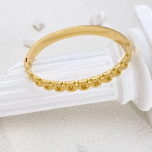 Minimalistisches Armband aus Gold-Titanstahl für Damen auf weißem Displayständer
