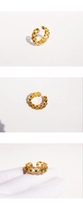 Detail of vintage gold lace ring featuring emerald green and white zircon stones