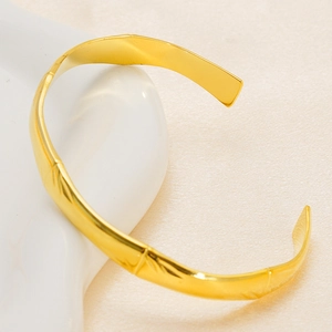 Gros plan détaillé d'un bracelet ouvert doré 18K au design de bambou élégant