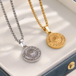 Detailed macro view of 18K gold and silver sun pendant necklaces in a jewelry box