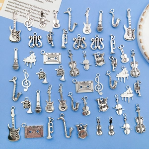 Antique silver musical instrument charms including guitar, violin, and notes on blue background