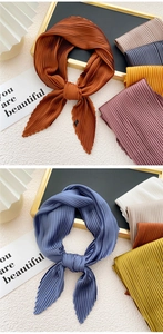 Detailed close-up of pleated satin scarves in vibrant orange, blue and yellow tones