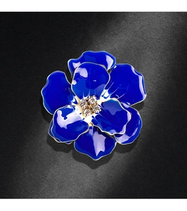 Detailed close-up of blue enamel flower brooch with gold plating and sparkling crystals