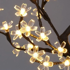 Close-up of warm yellow LED cherry blossom tree lights with realistic brown branches