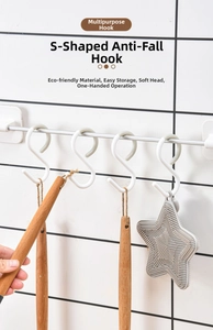 Detail of S-shaped anti-drop plastic hook hanging kitchen utensils on a steel rod
