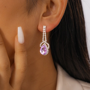 Detail of purple teardrop crystal earrings with sparkling rhinestones on model