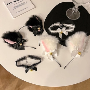 Détail d'oreilles de chat en peluche avec chokers en dentelle et cloches dorées