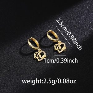 Macro shot of gold hoop earrings with sparkling love heart charm on black leather