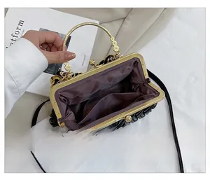 Detail view of black pleated shell bag showing golden ring handle and spacious interior