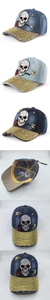 Detailed view of skull and rose embroidery with gold studs on washed denim baseball cap
