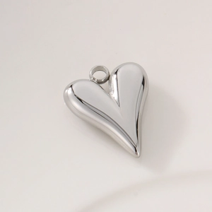 Close-up of polished stainless steel heart pendant with smooth metallic texture