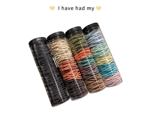 Detail of four jars with assorted multi-colored elastic hair ties and hair ropes