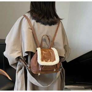Brown suede and PU leather backpack shown on model back in a lifestyle interior setting
