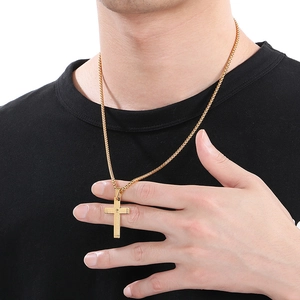 Close-up of golden stainless steel cross necklace with engraved scriptures on male model