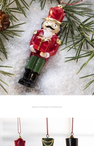 Detail of Nutcracker resin ornament with red gift box and festive bell hanging decoration