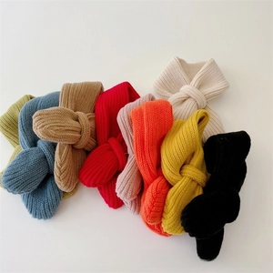 Macro view of multi-color ribbed knit scarves showing soft texture and cross-loop design