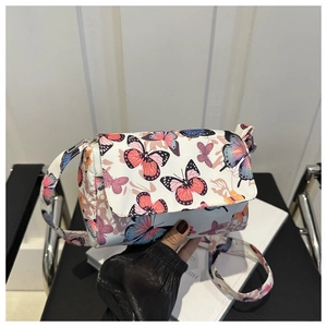 Detail of white butterfly print crossbody bag with colorful patterns and metal zipper