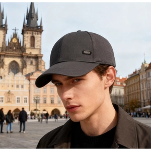 Detail view of sport baseball cap with metal logo on side worn by male model