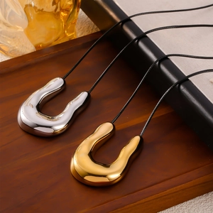 Minimalist titanium steel U-shaped pendant necklaces with woven leather cords on wooden tray