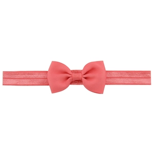 Detailed macro view of coral pink ribbed bow on seamless elastic nylon baby headband