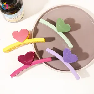 Detailed set of four colorful large hair claws with sweet heart accents on a tray