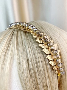 Close-up of handmade gold leaf headband with crystal beads worn by a model