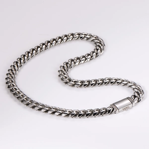 Detailed close-up of a polished silver Cuban chain with a diamond-encrusted square buckle