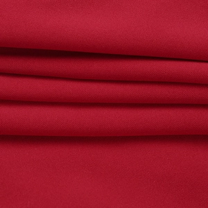 Détail macro du tissu rouge foncé montrant la texture fine et les plis élégants