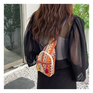 Detailed view of bohemian woven chest bag with colorful geometric patterns and tassels