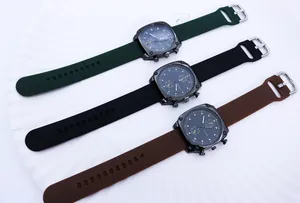 Three square quartz watches with green, black, and brown silicone straps on a white tray