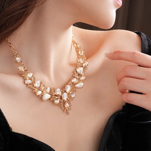Close-up of gold-plated necklace with sparkling oval diamonds worn on a model