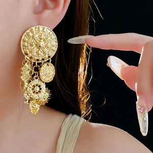 Details von Vintage Gold-Ohrringen mit runden Anhängern an einem Modell gezeigt