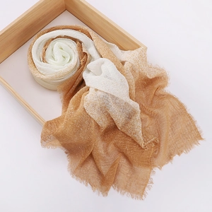Detail of silk cotton scarf with brown gradient dye and soft fringe on wooden tray