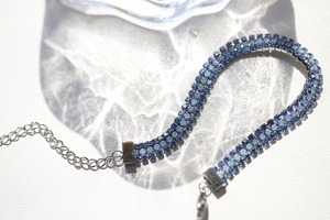 Macro shot of silver triple-row bracelet with gradient blue rhinestones and lobster clasp