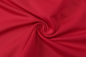 Gros plan détaillé sur la texture douce et le tissage élastique du tissu tricoté rouge