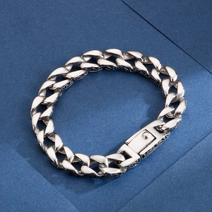 Detail of silver Cuban chain bracelet with side engraved patterns on polished steel