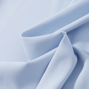 Macro view of light blue mesh fabric texture with soft natural folds and draping