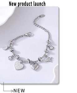 Detail of silver stainless steel charm bracelet featuring star, moon, and heart pendants